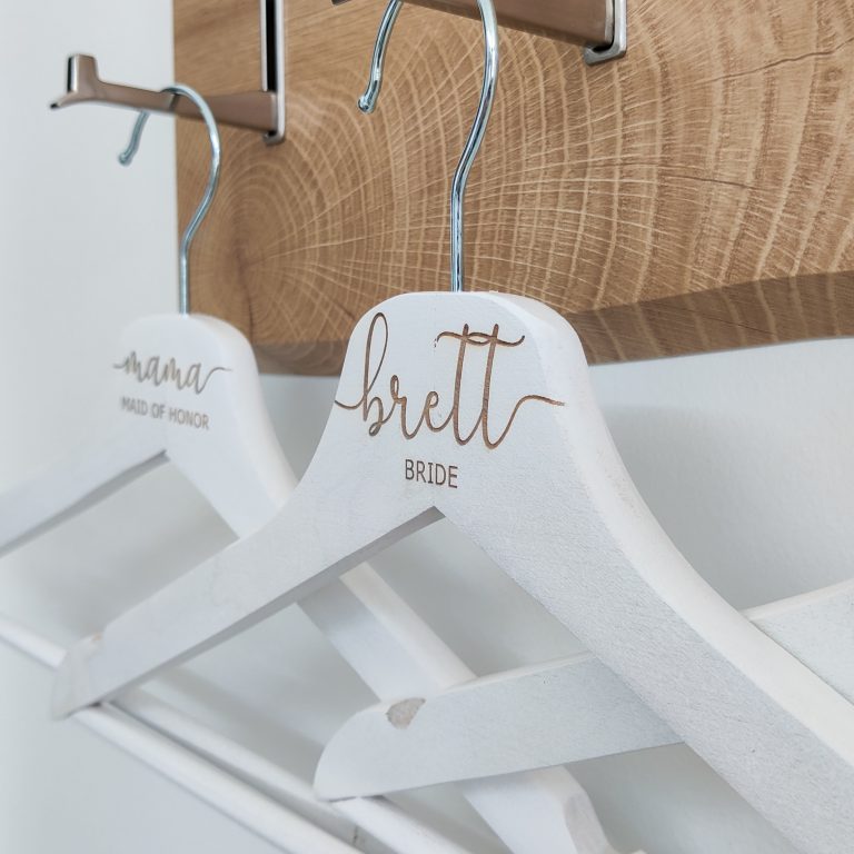 Elegante gepersonaliseerde kledinghangers klaar om de grote dag extra bijzonder te maken.